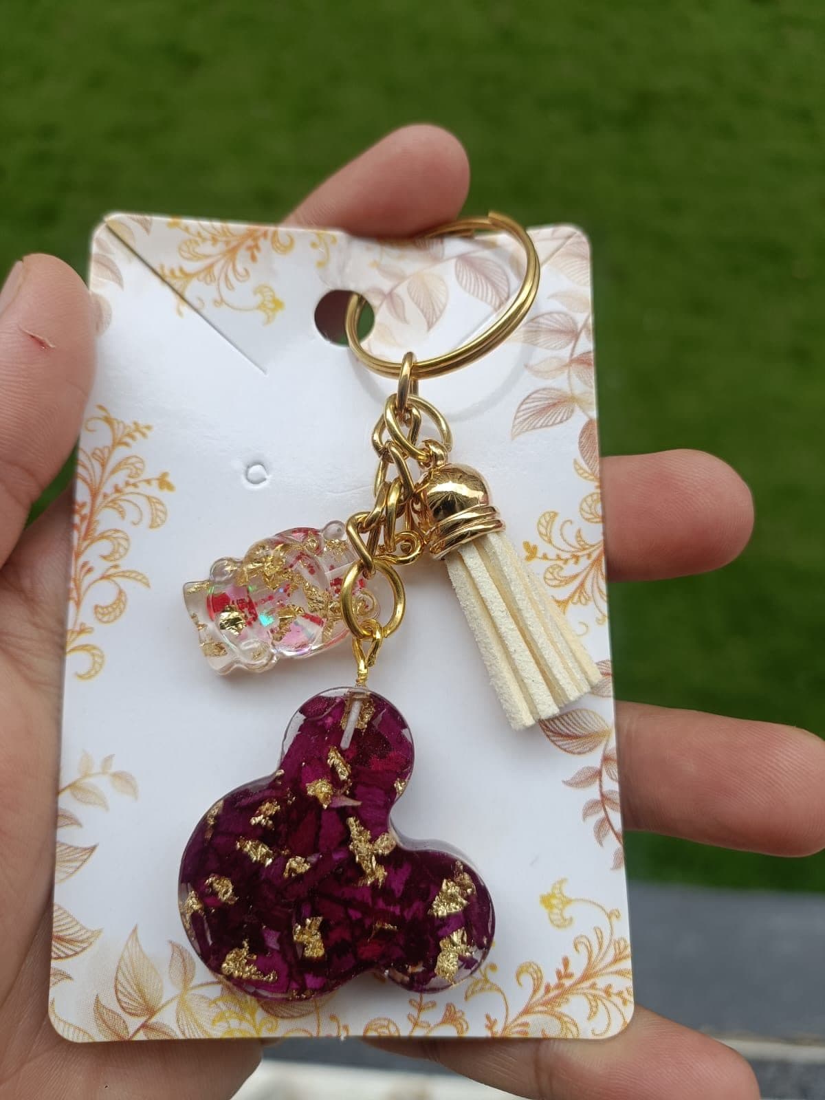Heart-shaped resin keychain with gold flakes on a display card